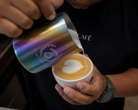 A person pouring milk/cream into a coffee