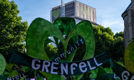 Grenfell Tower block and heart signs in green saying 'Grenfell'