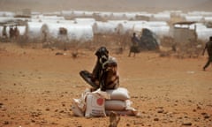 A Somali refugee wipes his face as he sits on sacks of food aid he received at a food distribution point in the Kobe refugee camp near the Ethiopia-Somalia border on July 19, 2011. Ethiopian authorities and non-governmental organizations have accomodated almost 25,000 refugees at the camp since it was set up less then three weeks ago. Thousands of Somalis have fled in recent months to neighbouring Ethiopia and Kenya in search of food and water, with many dying along the way, as the region suffers what the UN has described as the worst drought in decades. AFP PHOTO/ROBERTO SCHMIDT (Photo credit should read ROBERTO SCHMIDT/AFP/Getty Images)