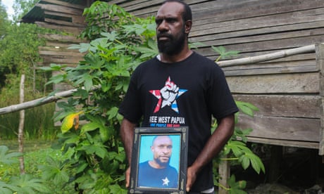 Charles Sraun holds a picture of Kristian Yandun in Merauke, West Papua