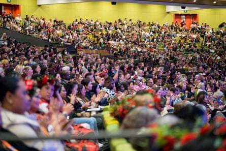 A seated audience in a crowded conference hall