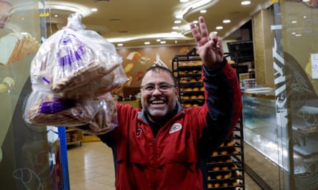 A man reacts as he buys bread on his way back to southern Lebanon