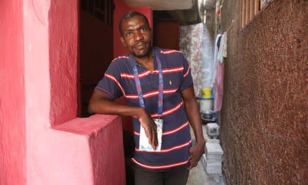 Man in T-shirt and lanyard looks at camera