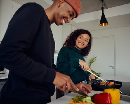 Happy couple preparing food and smiling.