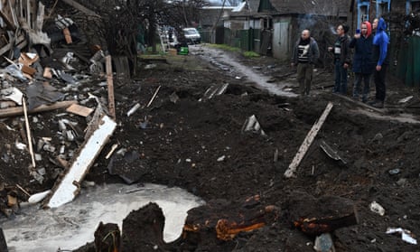 Residents stand near a crater as they inspect houses that were damaged after Russian shelling in Kramatorsk, Ukraine.