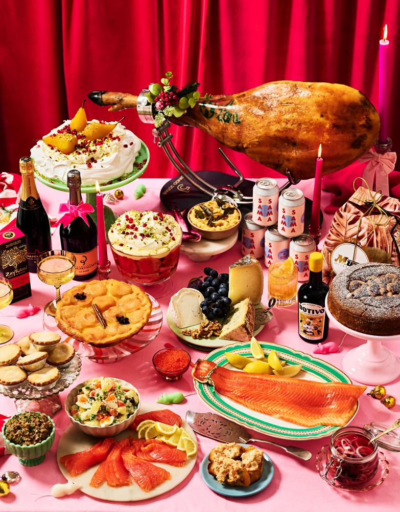 Photograph of a whole range of foods including a pavlova, a whole leg of jamon, trout, beer and cake