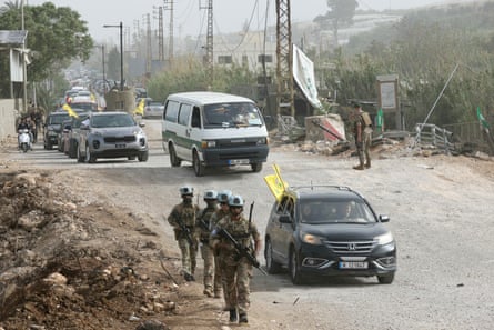 French UN peacekeepers patrol a road near a bridge destroyed by Israeli strikes in Al-Qasmiyeh area of southern Lebanon as displaced people waving Hezbollah flags make their way back to their homes.