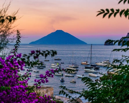 A small volcanic island rising from the sea in the distance.