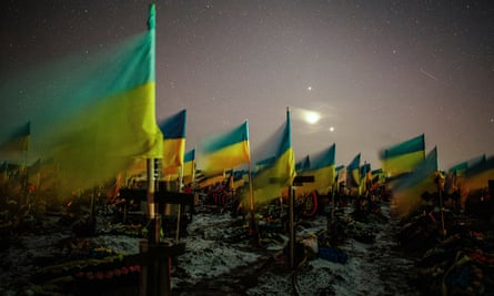 Ukrainian flags mark the graves of fallen soldiers at Kharkiv cemetery, 22 February 2023