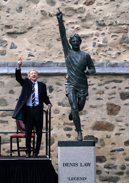 Denis Law poses with his statue in Aberdeen.