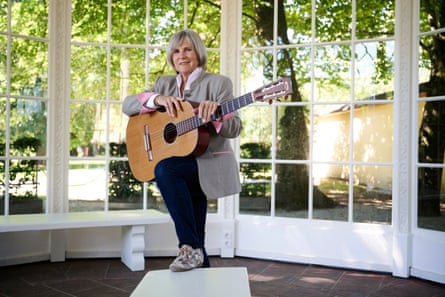 A woman with a guitar, standing in the original gazebo