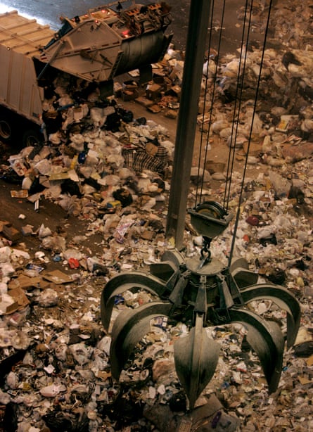 A crane operated by Bob Hammer’s claw hovers over a huge pile of garbage