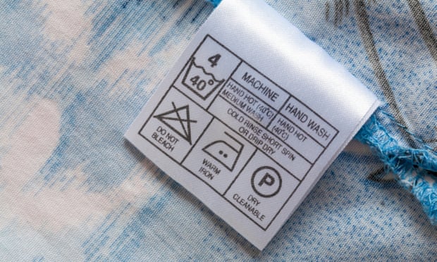 A close up of a care label on the inside of a garment. “P” on this care label means any solvent can be used on the garment except perc