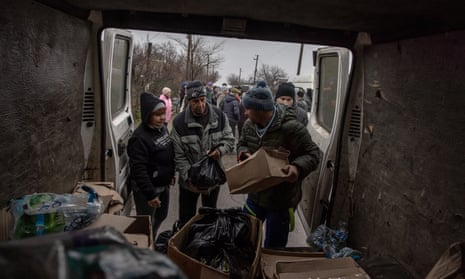 Local people receive humanitarian aid from volunteers at a frontline village in the Beryslav district, in Kherson region, southern Ukraine.