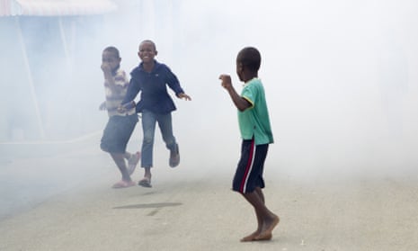 Children in the Dominican Republic running from fumes as air force personnel fumigate against the Aedes aegypti mosquito, vector of the Zika virus.