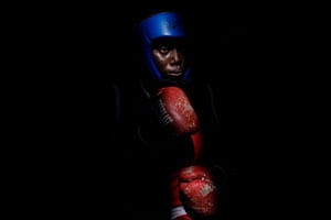 Damilola Adigun in deep shadow with blue headguard and red gloves