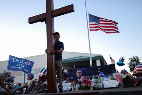 person carries a large cross near a memorial person carries a large cross near a memorial