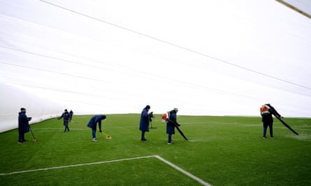 Le personnel au sol travaille sous une couverture sur le terrain avant le match de Chelsea contre Liverpool à Kingsmeadow.