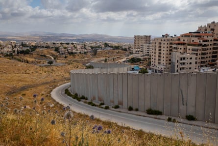 a barrier next to buildings and an expanse of grass