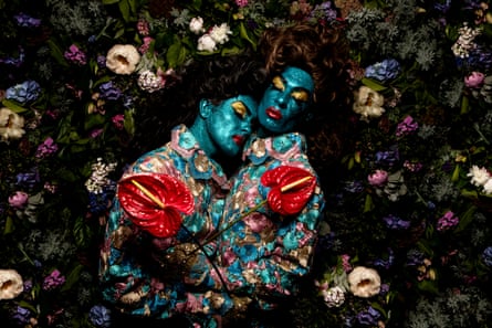 A portrait of the couple in bright costumes with metallic blue face paint