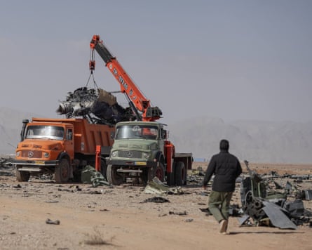 A crane lifts debris on to the back of a lorry