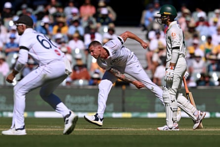 Brydon Carse sends down a delivery in intense heat late on day one.