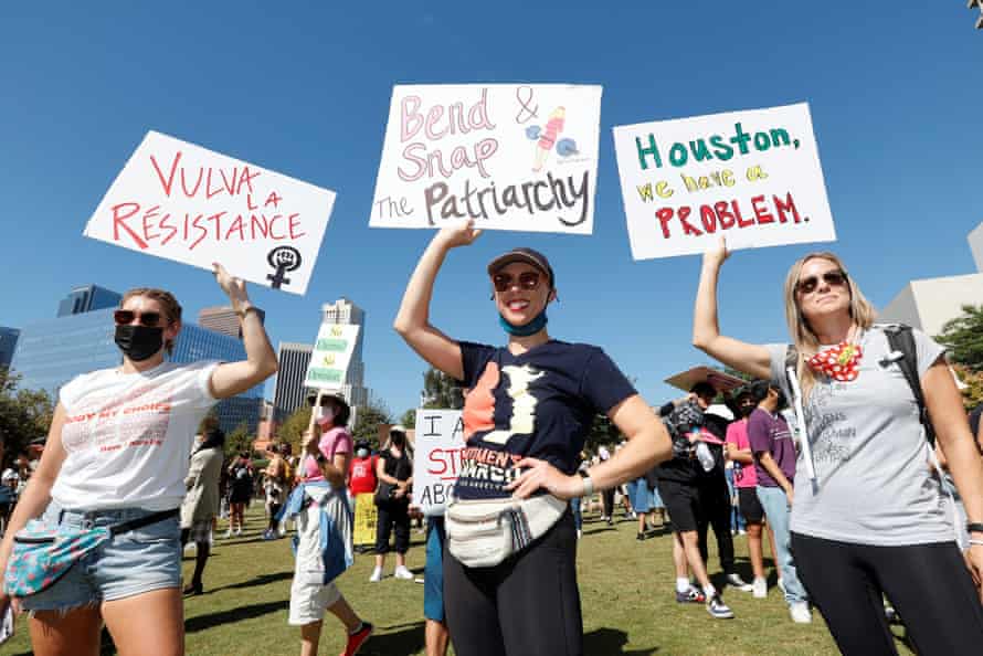 Pro-choice supporters hold signs reading "Vulva la resistance", "Bend and snap the patriarchy" and "Houston, we have a problem" at the Women's March in Los Angeles.