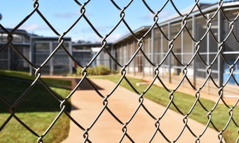 View of a prison courtyard seen through a wire fence