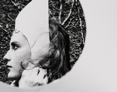 A person in a paper hat, viewed through a hole in paper