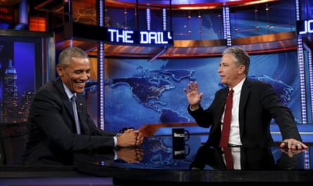 two men in suits smiling and talking at table