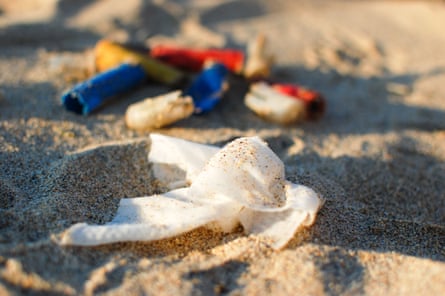 Closeup of a discarded wet wipe on a beach.