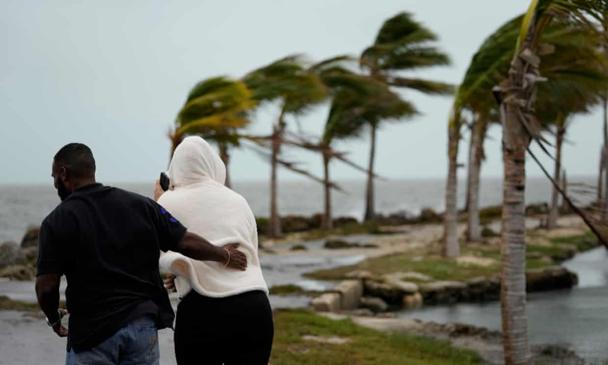 People brave gusty winds and drizzling rain in Coral Gables, Florida, on 15 December. Photograph: Rebecca Blackwell/AP