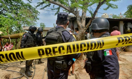 Police outside the house where were six people – including a four-month-old baby – were killed by gunmen in San Pedro Cacahuatepec near Acapulco.