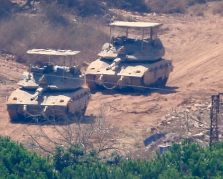Israeli tanks on dusty road as seen from distance