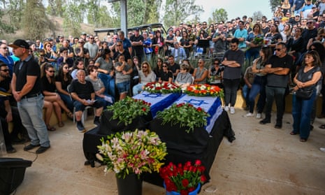 Mourners beside two coffins