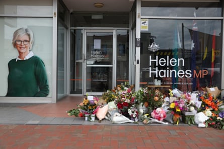 Floral tributes lie outside Helen Haines MP’s office, beside a portrait of her smiling