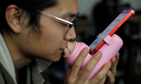 Jing Zhiyuan uses a remote kissing device "Long Lost Touch", as he demonstrates how to use it at his home in Beijing, China.