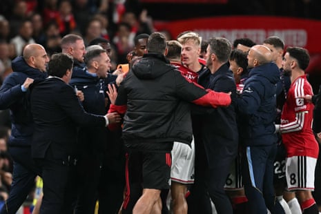 Players are separated by members of staff from both teams after a clash between Tottenham Hotspur's Rodrigo Bentancur and Manchester United's Luke Shaw.