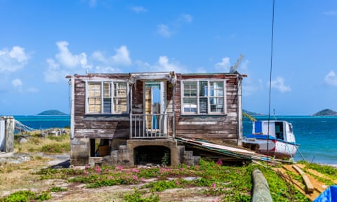 a weathered house by the water with no roof