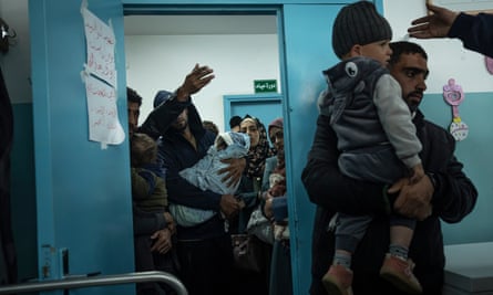 Palestinians line up with their children to receive vaccination against diseases.