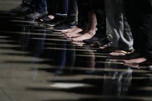 Migrants, some of them barefoot, line up on the quay after disembarking in the port of Roccella Ionica, Calabria, Italy