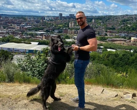 Atop a hill overlooking a city, the dogs stands on its hind legs, holding Stephen’s hands