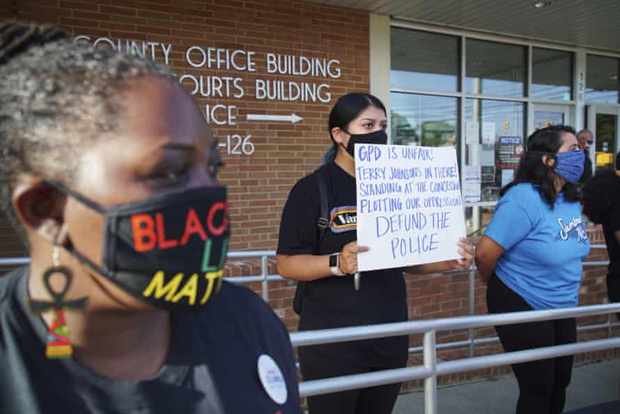 Aranza Sosa, center, holds a sign at a protest in front of the Alamance county government building in Graham, North Carolina, on 3 August. Sosa, who was born in Mexico and is now a U.S. citizen, says the county is a hostile place for people of color.
