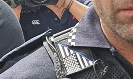 A police officer at a Black Live Matter rally in Brisbane on Friday, apparently wearing the ‘thin blue line’ symbol across the US flag.