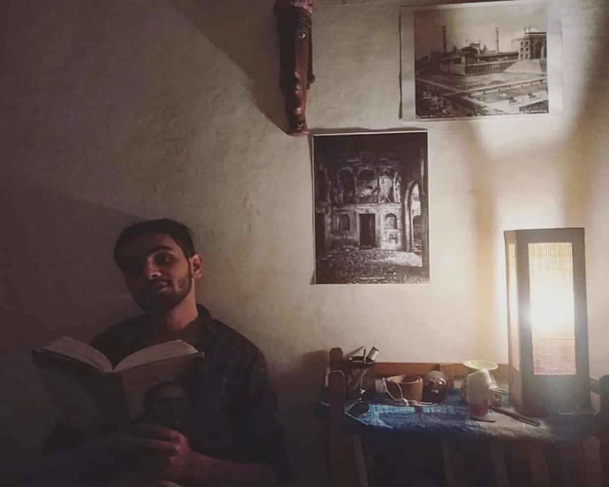 Umar Khalid, who has spent six years in an Indian jail without trial, reading a book in a dimly lit room