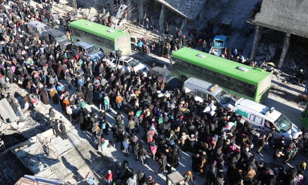 Crowds surround buses that are evacuating people from Aleppo.