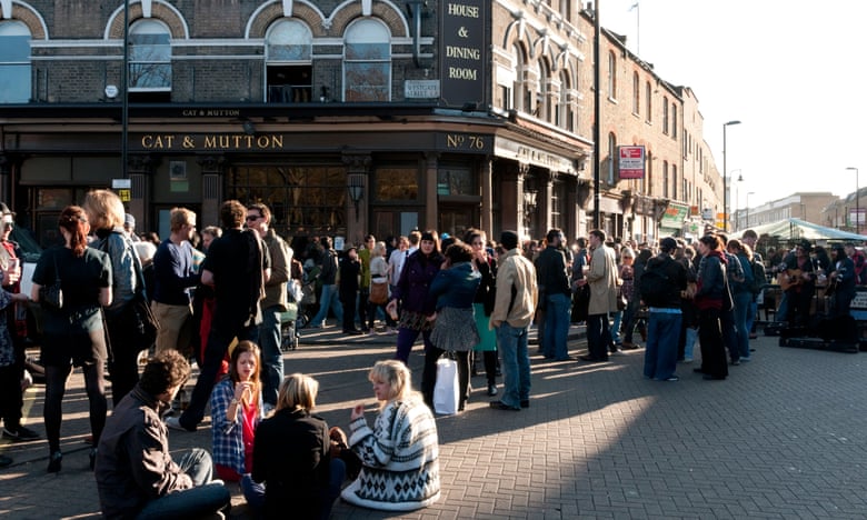 Young people drinking outside the Cat and Mutton pub on the corner of Broadway Market, Hackney, London, UK.