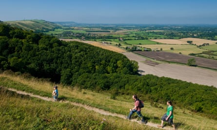 A family walks along the top of the South Downs escarpment in Sussex.