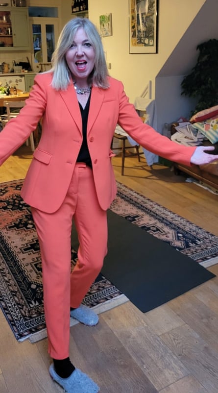 A blonde woman in an orange trouser suit.