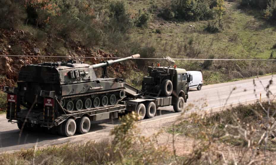 A Turkish army truck loaded with a tank heads to the Syrian border near Yayladagi, Turkey.
